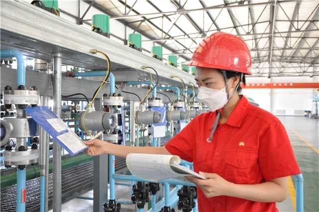 图为：采油三厂第五作业区注采506班组萨北14-5三元配注站站长王天在接到作业区数字化生产运行平台通知后核实注入井单井母液配比（拍摄者：孙博林）.jpg