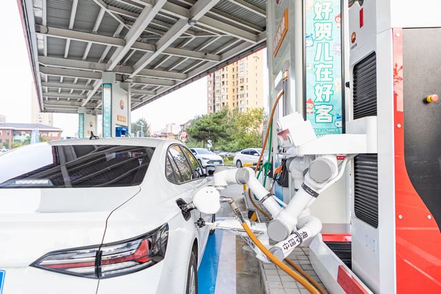 图为辽宁销售沈阳分公司蒲新路加油站加油机器人一气呵成完成开关油箱、提枪加油、关油箱盖等操作，成为媒体关注焦点。敦心旸摄.jpg