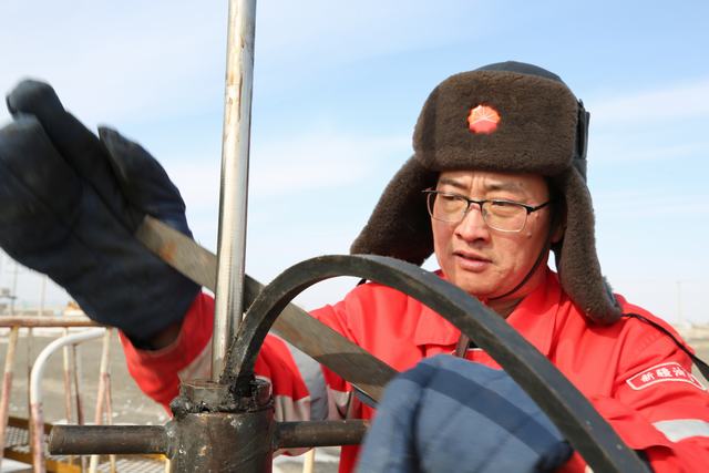 百口泉采油厂员工正在检查抽油机设备。摄影人：罗薇.jpg