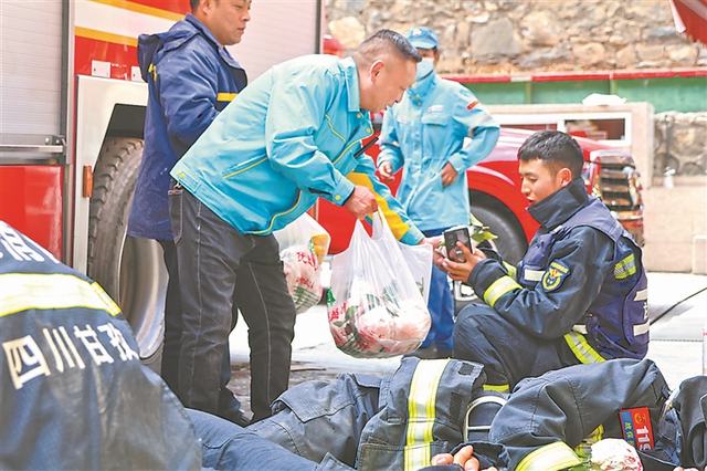 加油站员工为救援人员提供应急物资。李悦 摄.jpg
