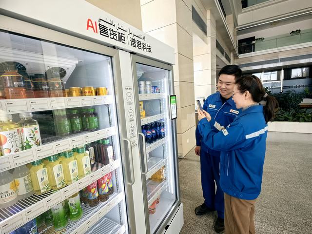 员工正在自动售货机前扫码购买零食。丁恬甜 摄.jpg